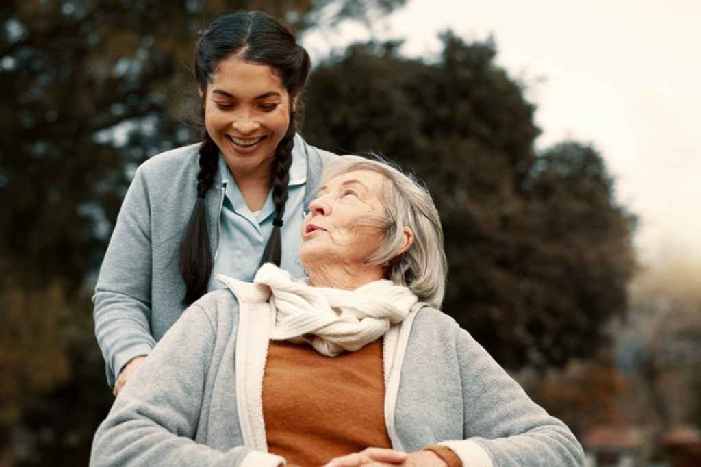 Smiling caregiver providing in-home support for an elderly woman in New Orleans